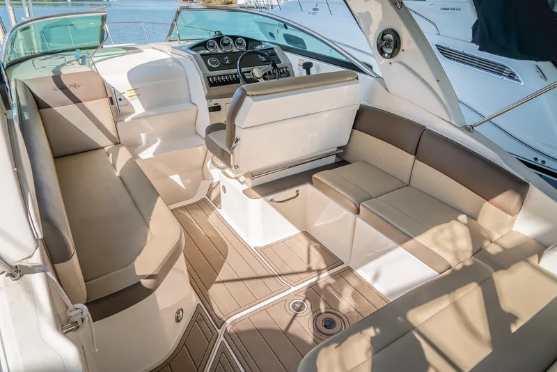Slide: The Image of 2014 Sea Ray 260 Sundancer interior with beige seating and modern dashboard. - 10