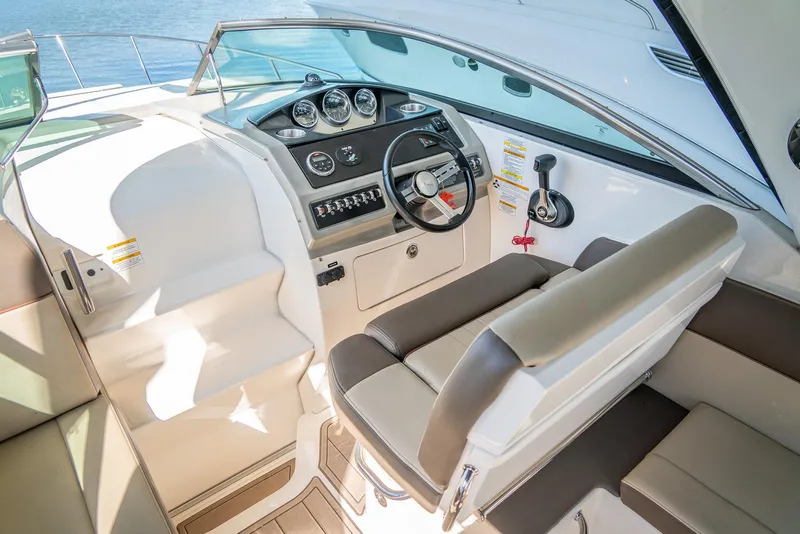 Slide: The Image of 2014 Sea Ray 260 Sundancer cockpit with steering wheel, gauges, and seating. - 12