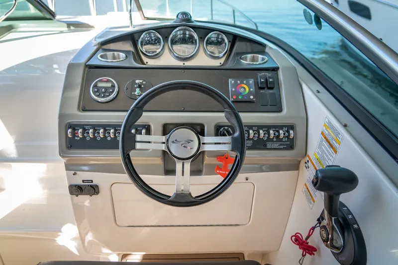 Slide: The Image of 2014 Sea Ray 260 Sundancer helm with steering wheel and control panel. - 13