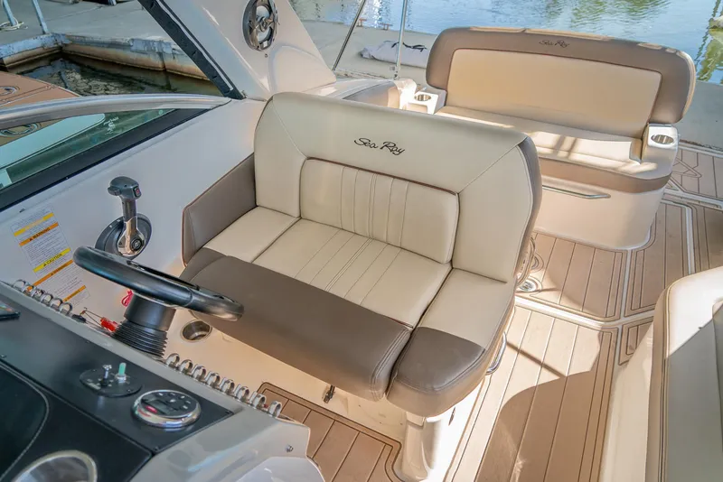Slide: The Image of Captain's seat on 2014 Sea Ray 260 Sundancer boat, featuring beige and brown upholstery. - 16
