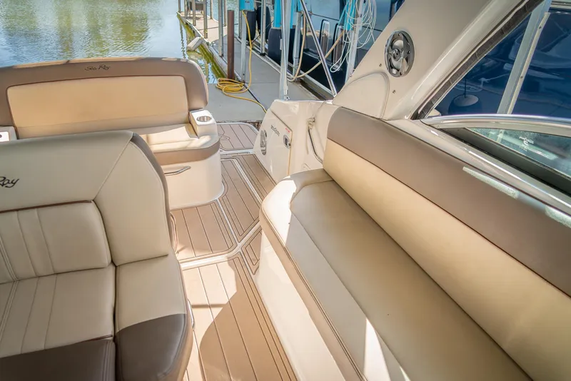 Slide: The Image of 2014 Sea Ray 260 Sundancer interior with beige seating and wood flooring. - 17