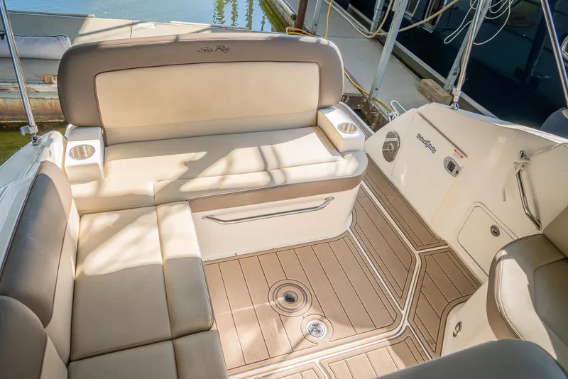Slide: The Image of 2014 Sea Ray 260 Sundancer boat interior with beige seating and wood-like flooring. - 18