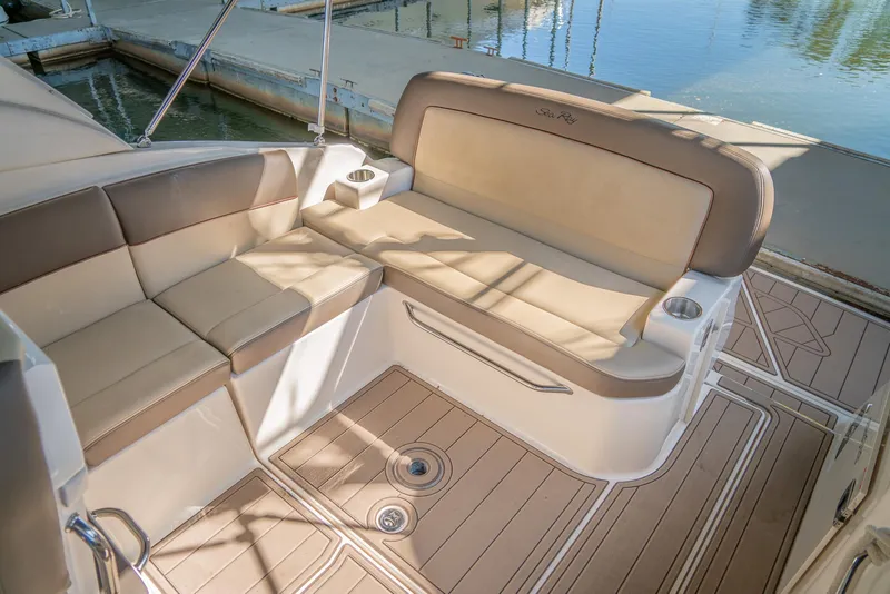 Slide: The Image of 2014 Sea Ray 260 Sundancer boat interior with beige seating and wood-style flooring. - 19