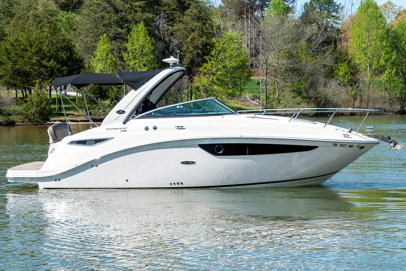 Slide: The Image of 2014 Sea Ray 260 Sundancer boat on a calm lake with lush green trees. - 2