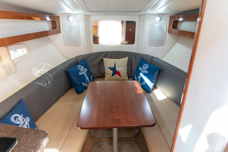 Slide: The Image of 2014 Sea Ray 260 Sundancer cabin with cozy seating and nautical-themed cushions. - 23