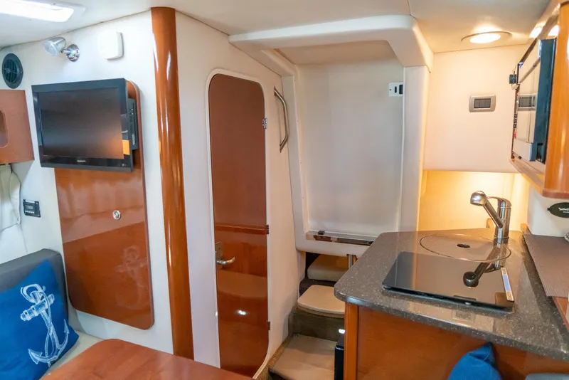 Slide: The Image of Interior of 2014 Sea Ray 260 Sundancer with kitchenette, TV, and seating area. - 27