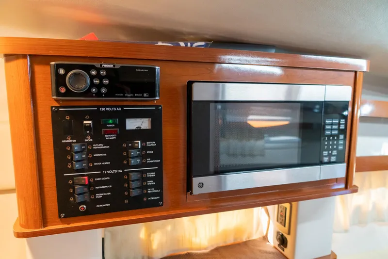 Slide: The Image of 2014 Sea Ray 260 Sundancer interior with control panel and microwave. - 29