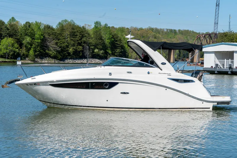 Slide: The Image of 2014 Sea Ray 260 Sundancer boat on a calm lake with trees in the background. - 3