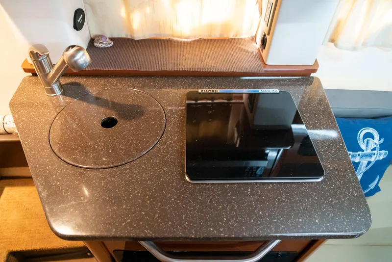 Slide: The Image of 2014 Sea Ray 260 Sundancer galley with sink and stovetop. - 30