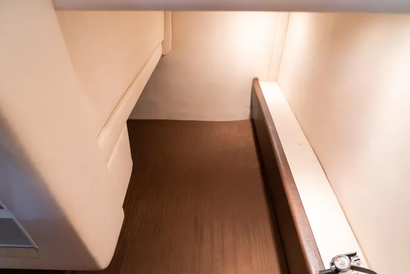 Slide: The Image of 2014 Sea Ray 260 Sundancer cabin interior with wood flooring and soft lighting. - 33