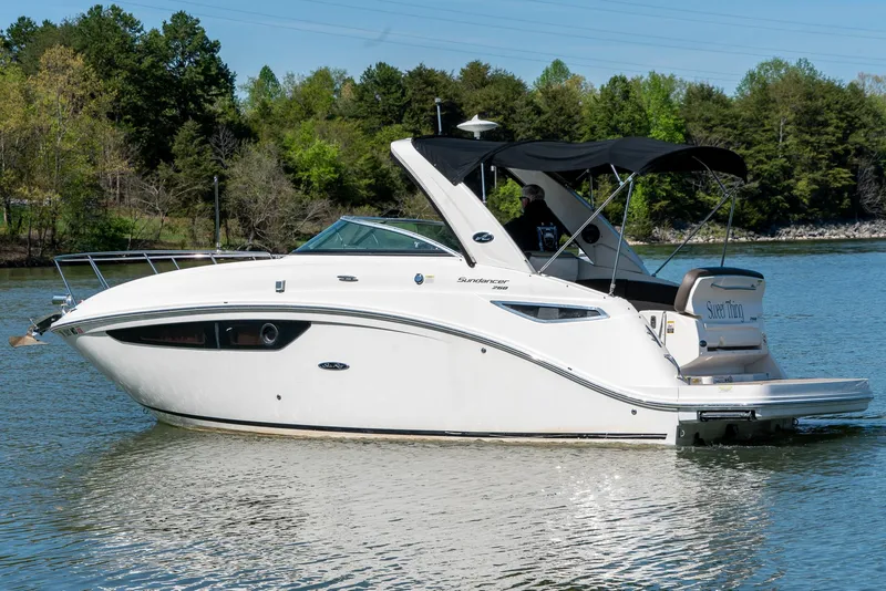 Slide: The Image of 2014 Sea Ray 260 Sundancer boat on a calm lake with lush green trees. - 4