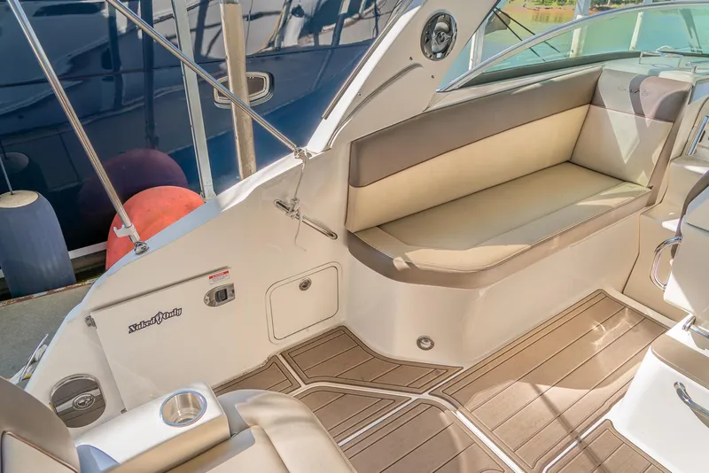 Slide: The Image of 2014 Sea Ray 260 Sundancer boat interior with cushioned seating and wood flooring. - 9