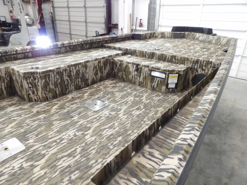 Slide: The Image of 2025 Avid 18 Commander boat with camouflage pattern in a garage setting. - 19