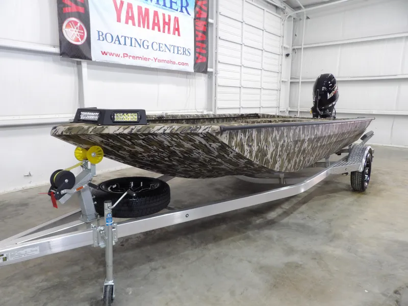 Slide: The Image of 2025 Avid 18 Commander boat on trailer in showroom, camo design, Yamaha banner in background. - 3