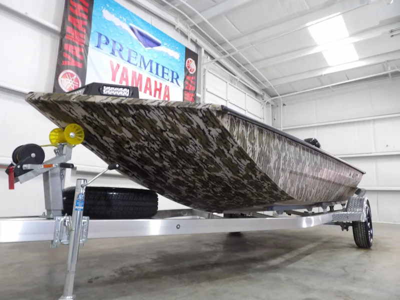 Slide: The Image of 2025 Avid 18 Commander boat with camouflage design on a trailer in a showroom. - 5