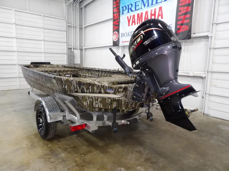 Slide: The Image of 2025 Avid 18 Commander boat with camouflage design and Yamaha outboard motor in showroom. - 7