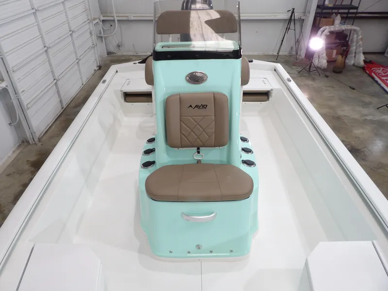 Slide: The Image of 2025 Avid 21FST boat interior with mint green console and tan seating in a garage. - 13