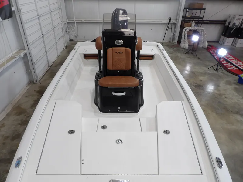 Slide: The Image of 2025 Avid 21FST boat interior with brown seating in a garage setting. - 11