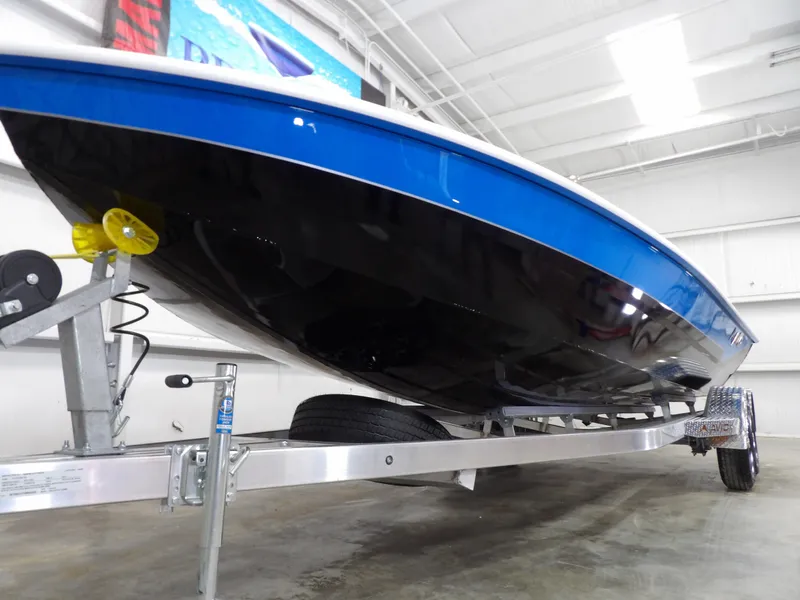 Slide: The Image of 2025 Avid 21FST boat on trailer, blue and black hull, indoor showroom. - 5