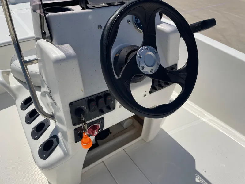 Slide: The Image of 2020 Mako Pro Skiff 17 steering console with black wheel and control panel. - 12