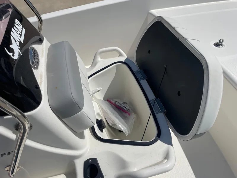 Slide: The Image of 2020 Mako Pro Skiff 17 boat storage compartment open, showing interior contents. - 15