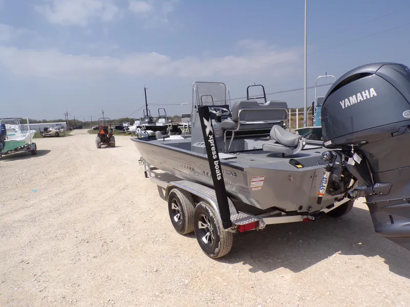 Slide: The Image of 2025 Xpress H210BAY boat with Yamaha engine on a trailer in a sunny outdoor setting. - 11