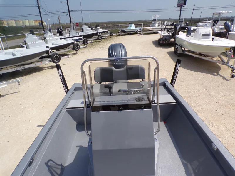 Slide: The Image of 2025 Xpress H210BAY boat interior with console, surrounded by other boats on trailers. - 20
