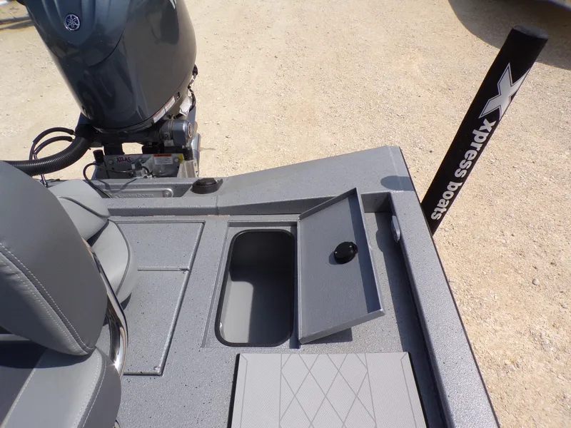 Slide: The Image of 2025 Xpress H210BAY boat with open storage compartment and Yamaha engine. - 23