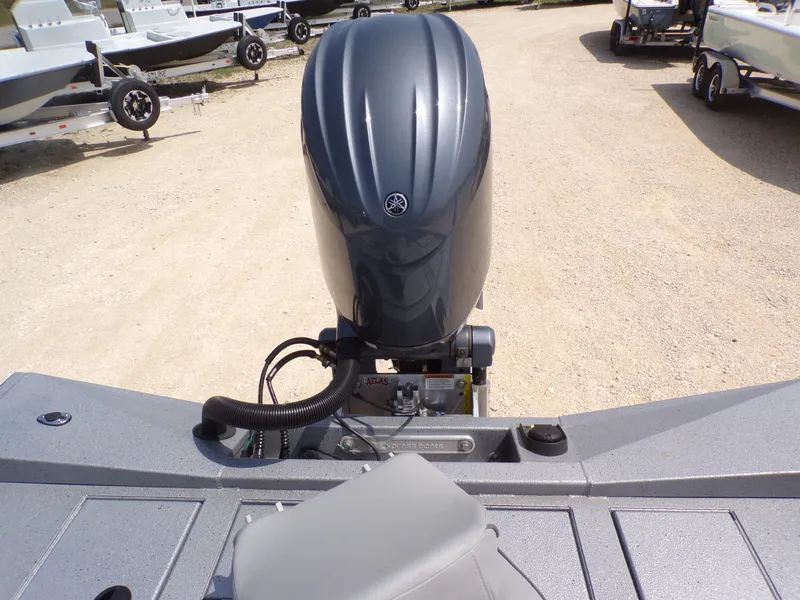 Slide: The Image of 2025 Xpress H210BAY boat with Yamaha outboard motor, parked on gravel lot. - 24