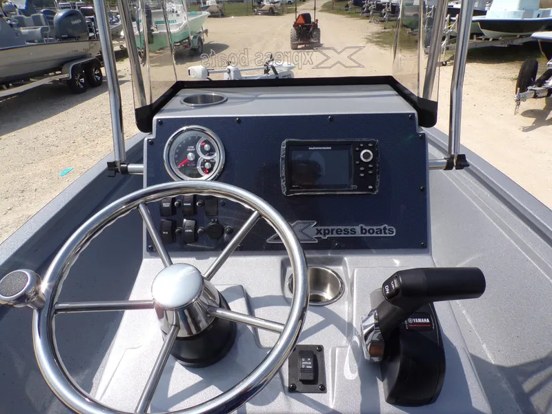 Slide: The Image of 2025 Xpress H210BAY boat dashboard with steering wheel, controls, and navigation display. - 26