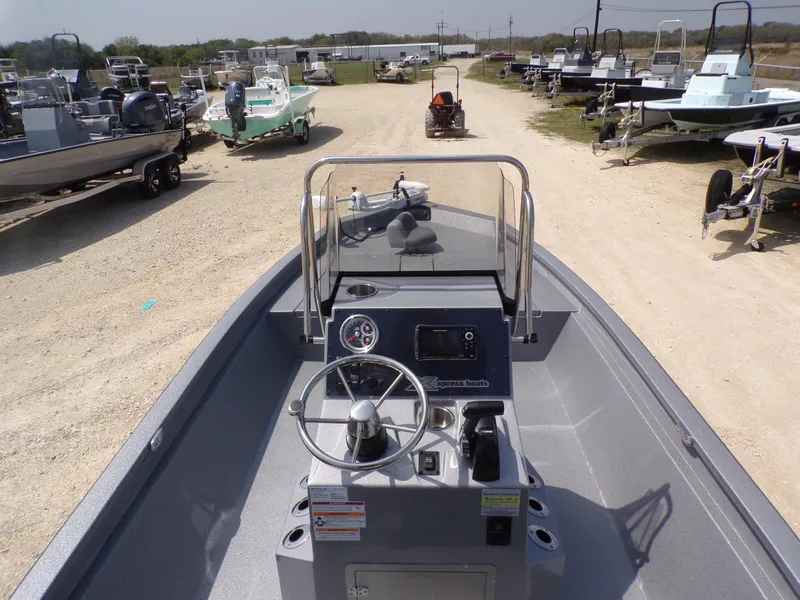 Slide: The Image of 2025 Xpress H210BAY boat interior with steering wheel and control panel, parked outdoors. - 29