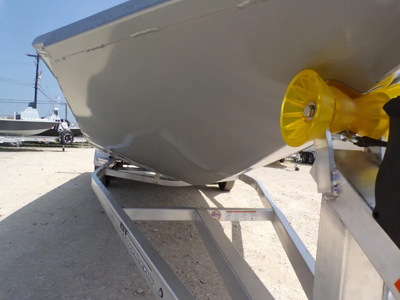 Slide: The Image of 2025 Xpress H210BAY boat on trailer, close-up view of hull and yellow roller. - 6