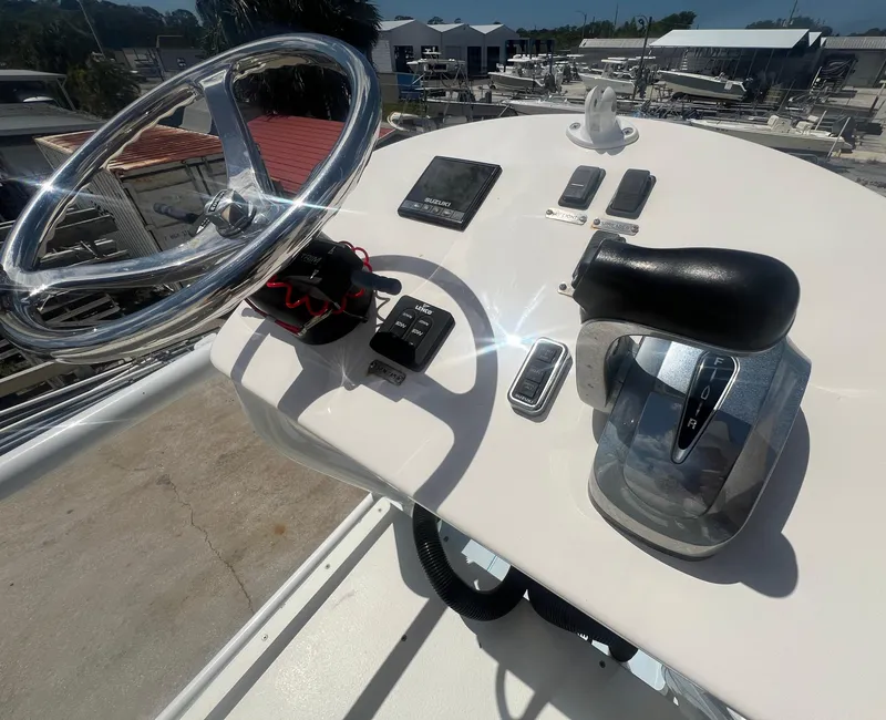 Slide: The Image of Control panel of a 2007 Young Boats Young 24, featuring steering wheel and throttle. - 13