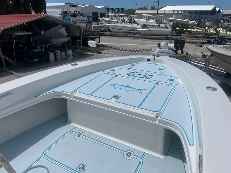 Slide: The Image of 2007 Young Boats Young 24, spacious deck with storage, docked at a marina. - 2