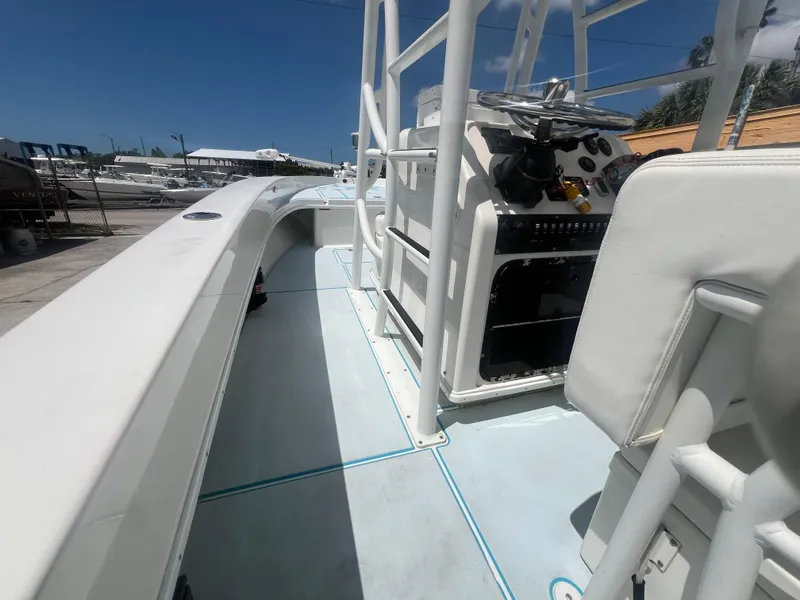 Slide: The Image of 2007 Young Boats Young 24 interior with console and seating, docked under clear blue sky. - 21
