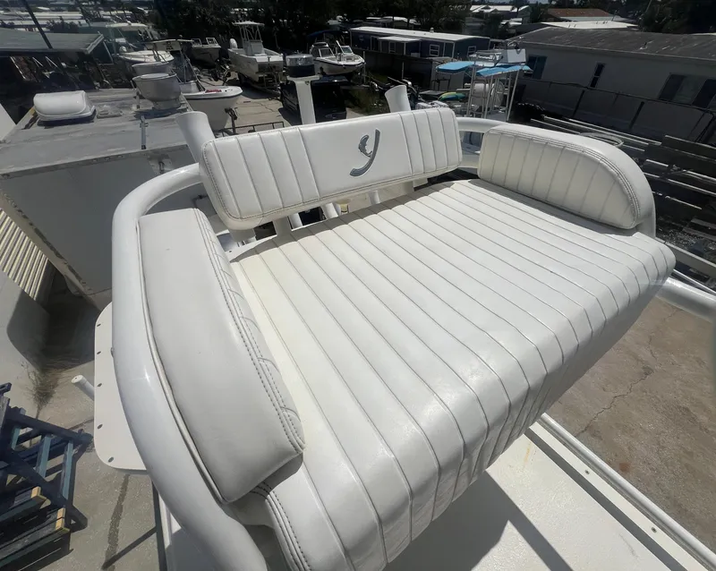 Slide: The Image of White cushioned seating on 2007 Young Boats Young 24, featuring a stylish "Y" logo. - 24