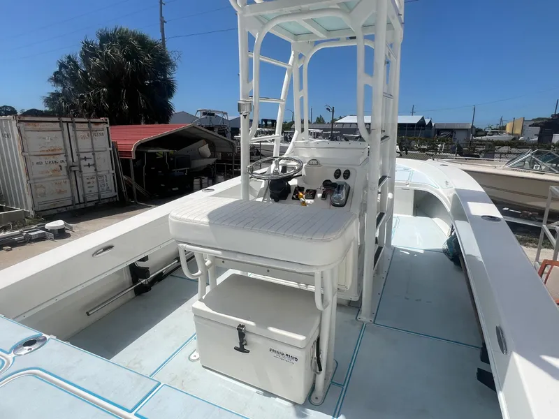 Slide: The Image of 2007 Young Boats Young 24 center console boat with T-top and seating, docked outdoors. - 25