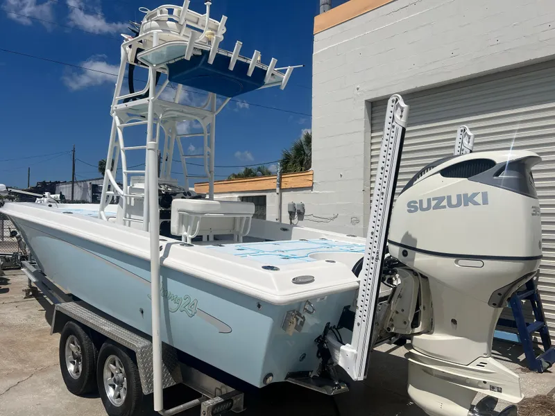 Slide: The Image of 2007 Young Boats Young 24 on trailer with Suzuki outboard motor, parked outdoors. - 26