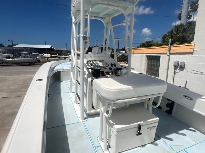 Slide: The Image of 2007 Young Boats Young 24 center console boat with seating and steering wheel, docked outdoors. - 6