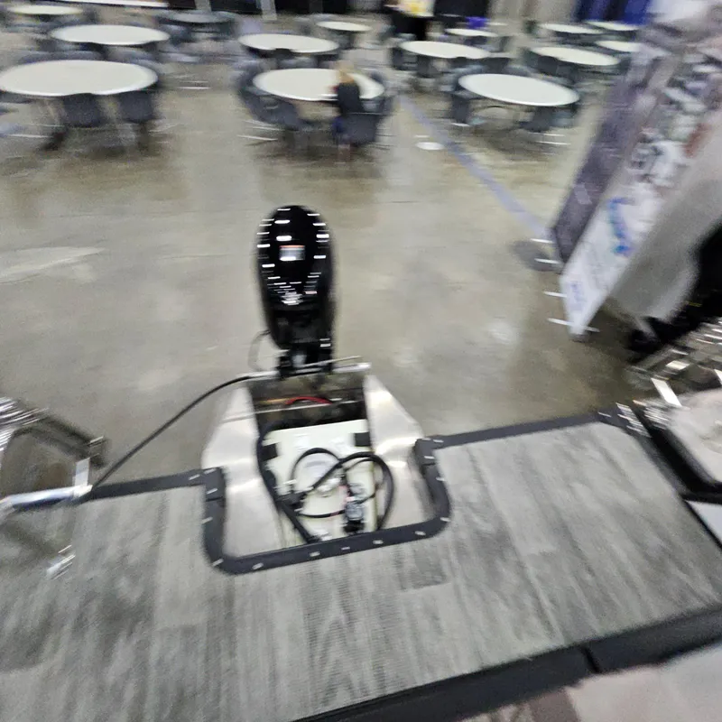 Slide: The Image of 2025 Qwest E 18 RLS boat motor displayed indoors with round tables in the background. - 19