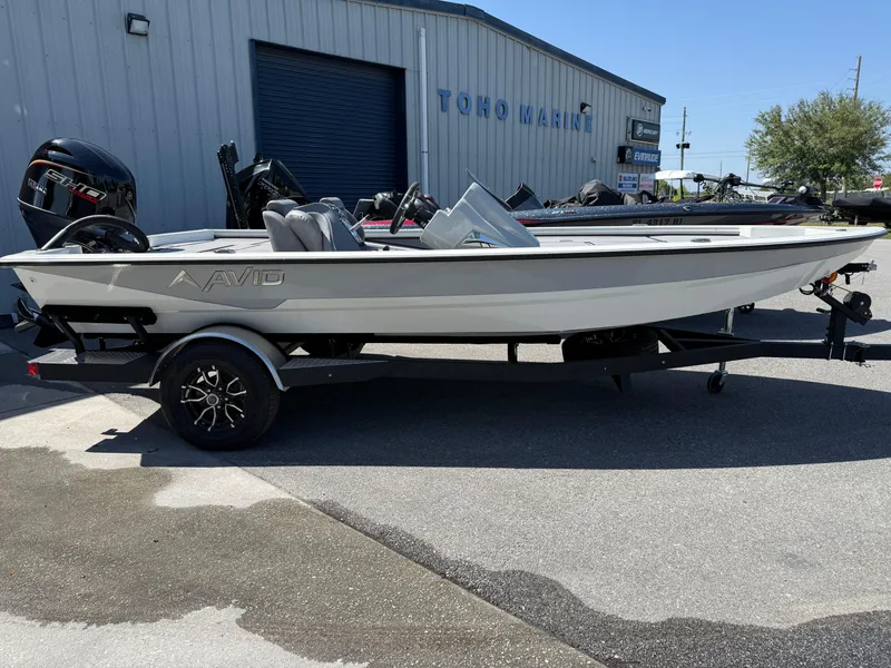 Slide: The Image of 2025 Avid 18 XB boat on trailer at dealership, side view. - 1