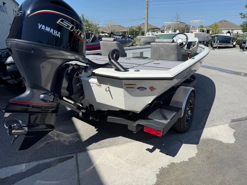 Slide: The Image of 2025 Avid 18 XB boat with Yamaha engine on trailer in sunny outdoor setting. - 11