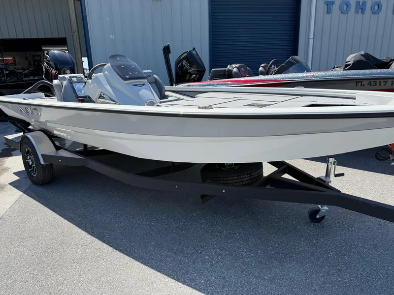 Slide: The Image of 2025 Avid 18 XB boat on trailer, parked outdoors in a marina setting. - 2