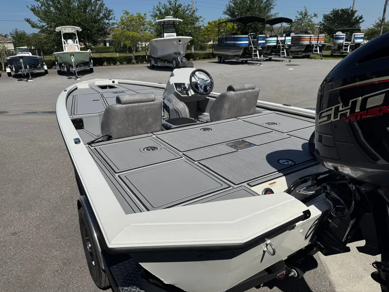 Slide: The Image of 2025 Avid 18 XB boat with sleek design, spacious deck, and powerful engine in a showroom. - 9