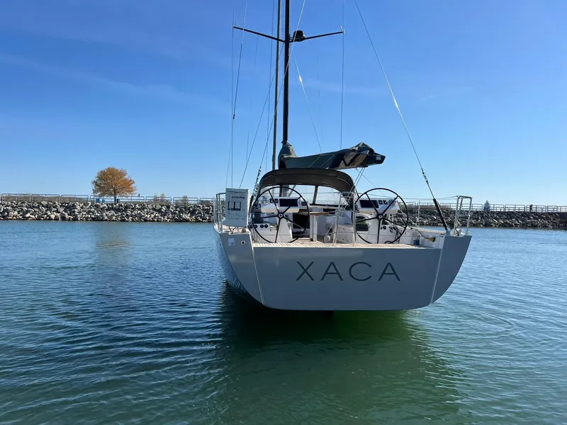 Slide: The Image of 2015 X-Yachts Xp 55 sailboat on calm water, rear view. - 12