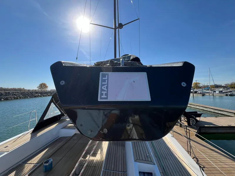 Slide: The Image of 2015 X-Yachts Xp 55 sailboat docked, viewed from the stern under a clear blue sky. - 27