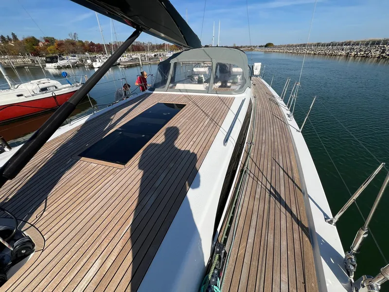 Slide: The Image of Xp 55 yacht deck with wooden finish, docked in a marina, sunny day. - 36