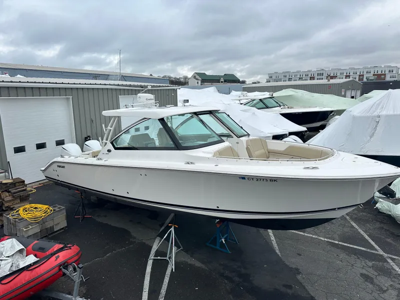 Slide: The Image of 2019 Pursuit DC 325 boat on stands in a marina storage area. - 0