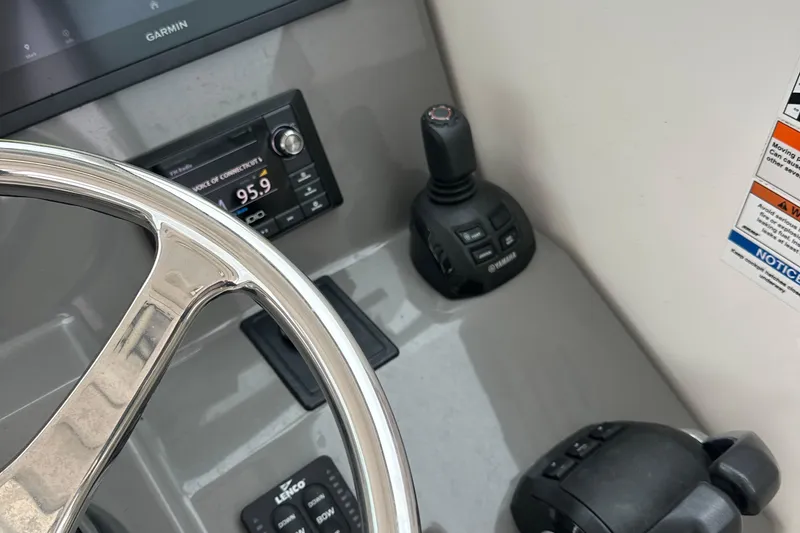 Slide: The Image of Control panel of 2019 Pursuit DC 325 boat with steering wheel and navigation instruments. - 11