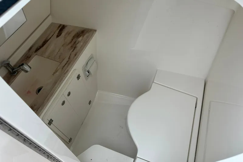 Slide: The Image of 2019 Pursuit DC 325 boat interior bathroom with sink and toilet. - 19